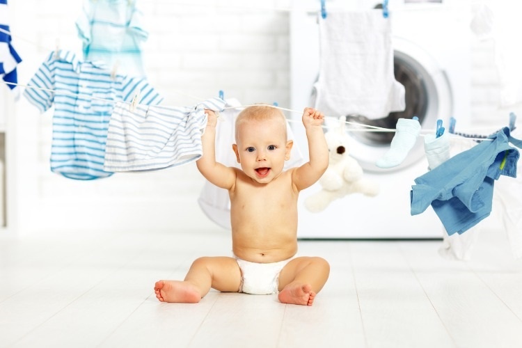fun-happy-baby-boy-to-wash-clothes-and-laughs-in-laundry-picture-id670677132