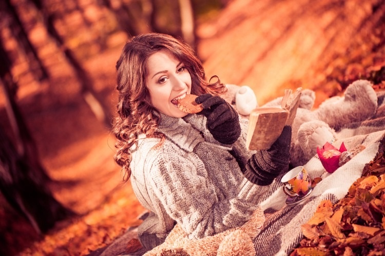 brunet-with-cookie-at-fall-forest-picture-id520980597