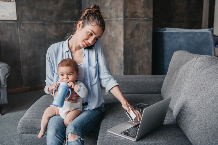 mother-with-baby-boy-remote-working-and-using-laptop-picture-id690396824