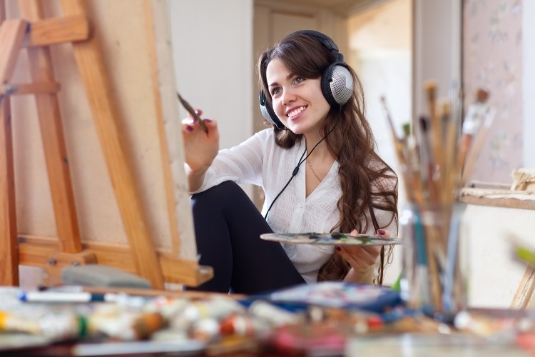 girl-in-headphones-paints-with-oil-colors-on-canvas-picture-id468716857