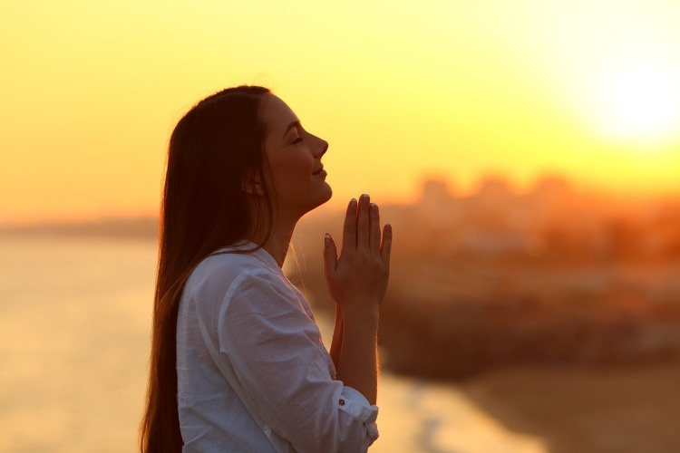 profile-of-a-woman-praying-at-sunset-picture-id915213254